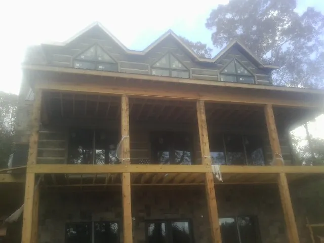 Dormers and porch framing on a large log home under construction — Roof Coating work by our crew in Thonotosassa